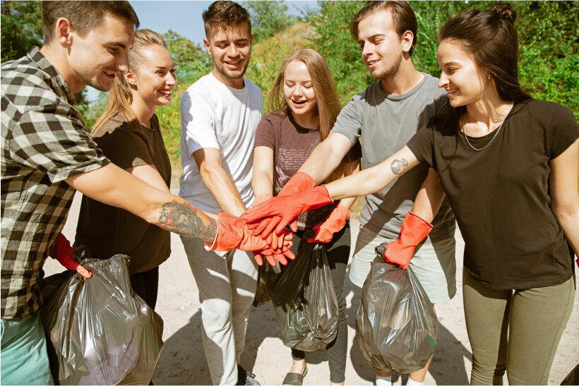 Menschen, die motiviert gemeinsam in eine Müllsammelaktion starten